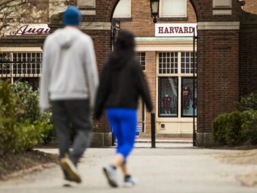 Pedestrians walk through Harvard Yard at Harvard University in Cambridge, Mass., on April 20, 2020. (Adam Glanzman/Bloomberg)