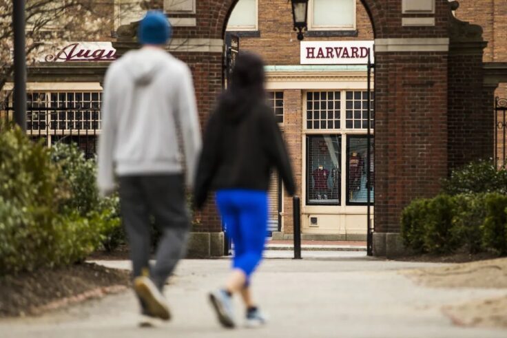 Pedestrians walk through Harvard Yard at Harvard University in Cambridge, Mass., on April 20, 2020. (Adam Glanzman/Bloomberg)