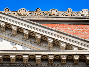 Detail of the Widener Library roof against a blue sky.
