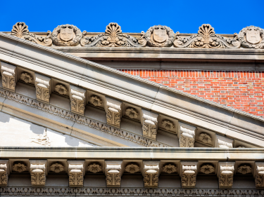 Detail of the Widener Library roof against a blue sky.