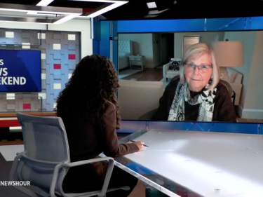 Joan Brugge speaking to PBS host Laura Barrón-López.