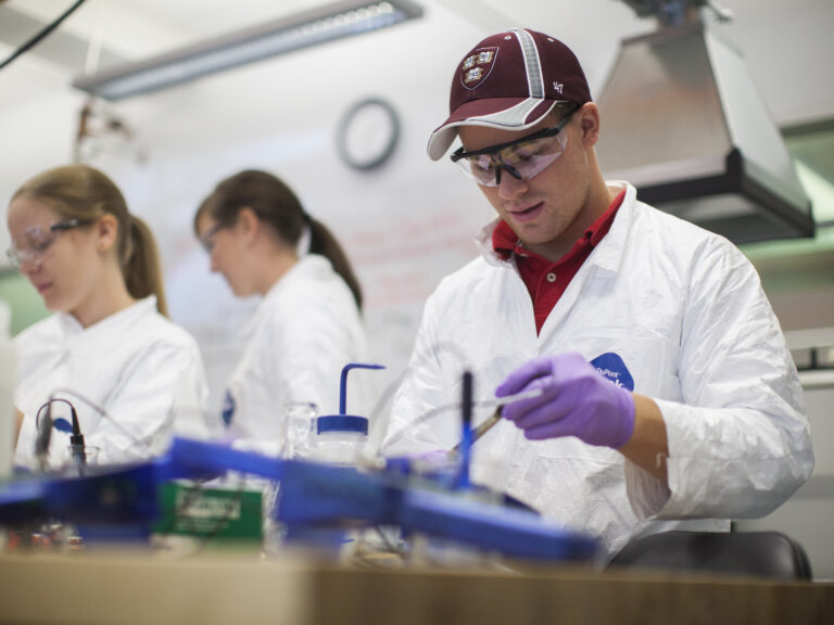students in lab coats in a lab