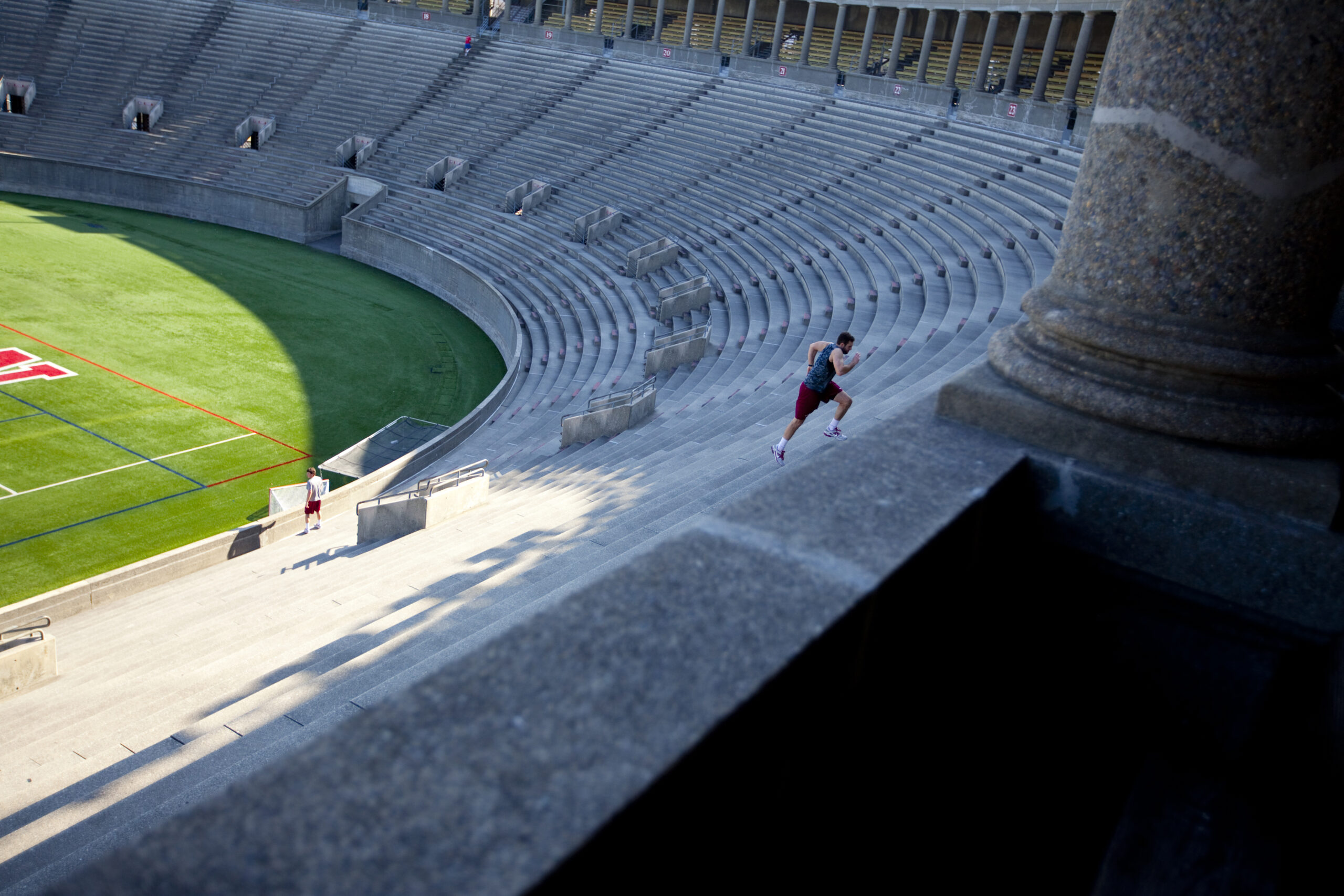 A man running up the steps in Harvard stadium