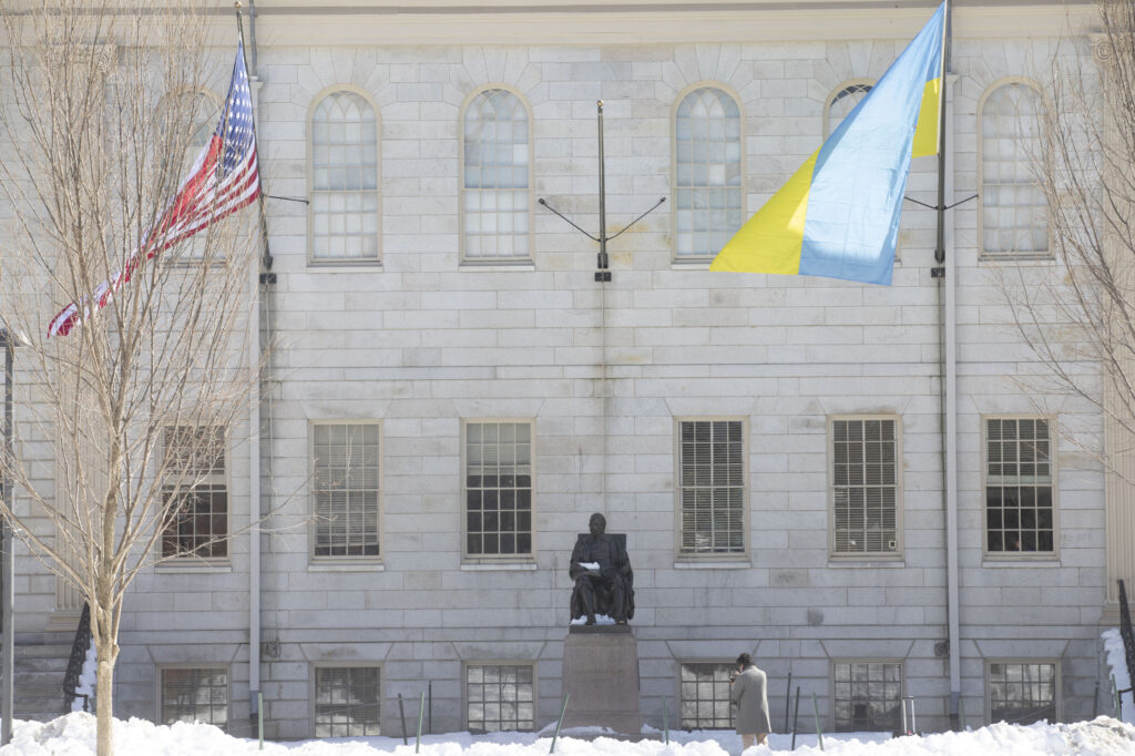 The flag of Ukraine and the U.S. flag flies over the John Harvard Statue.