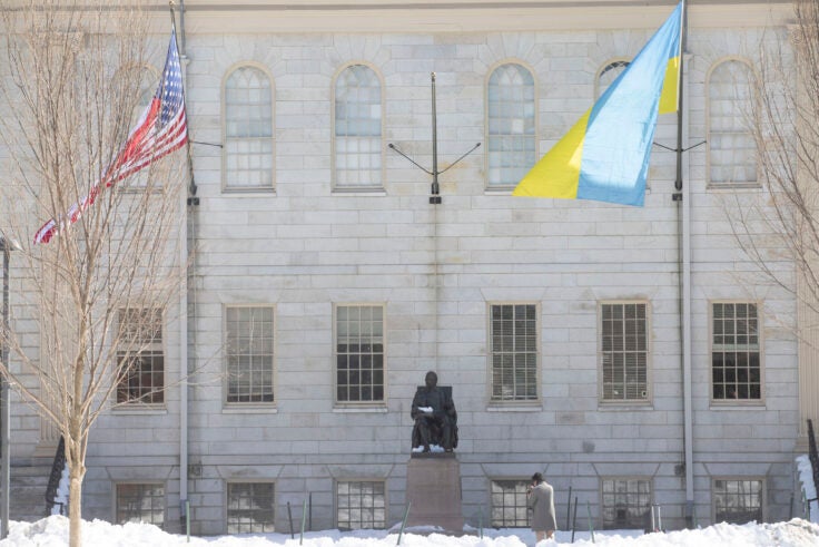 The flag of Ukraine and the U.S. flag flies over the John Harvard Statue.