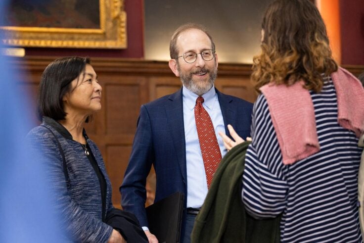 President Garber speaking with two women at Cambridge College.