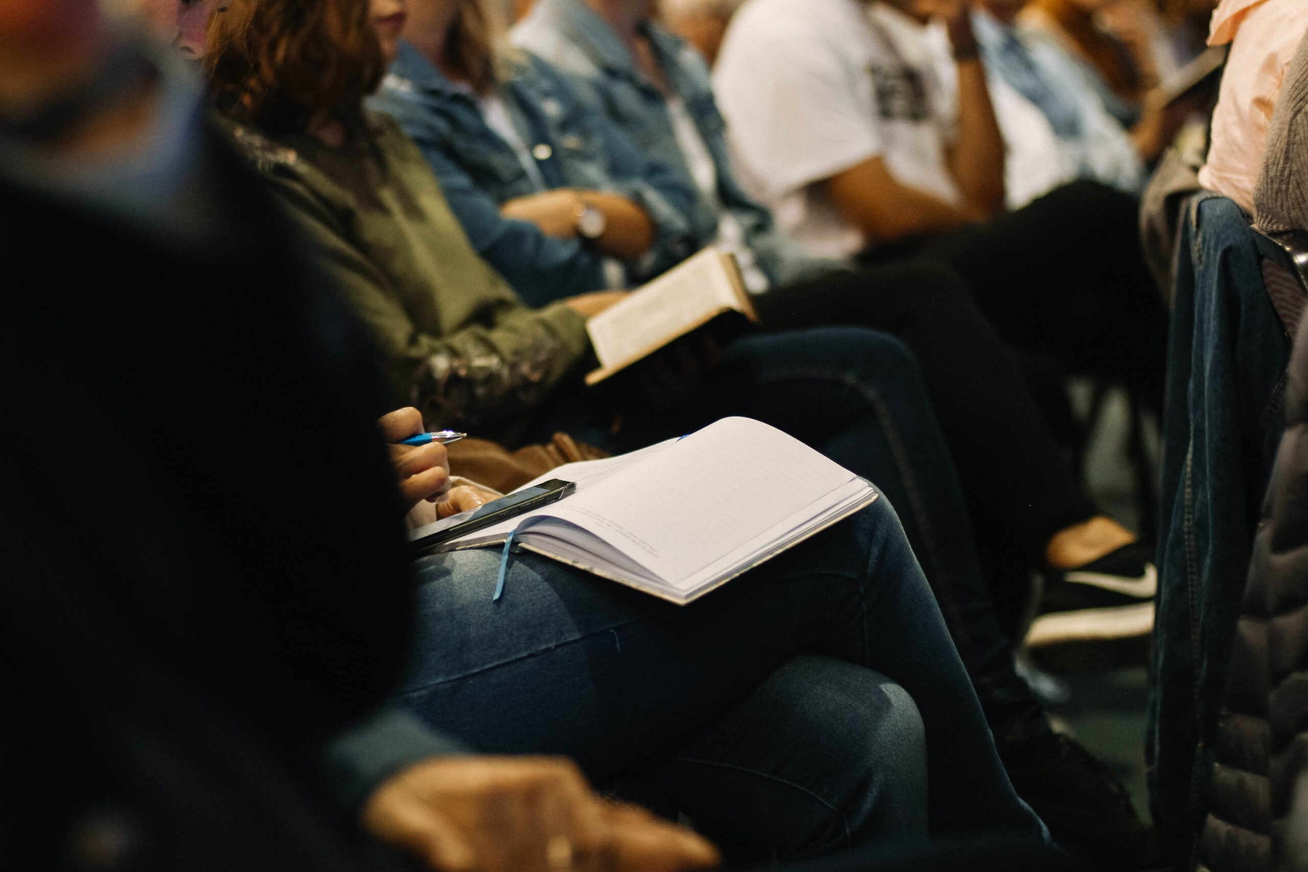 People taking notes in a crowd