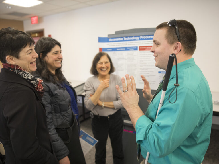 Four Harvard employees talk in a group.