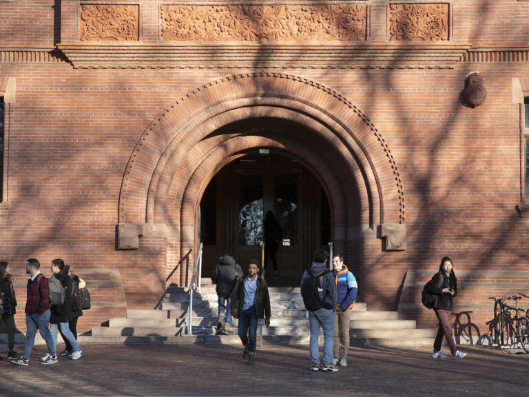 Students talking as they leave a building.