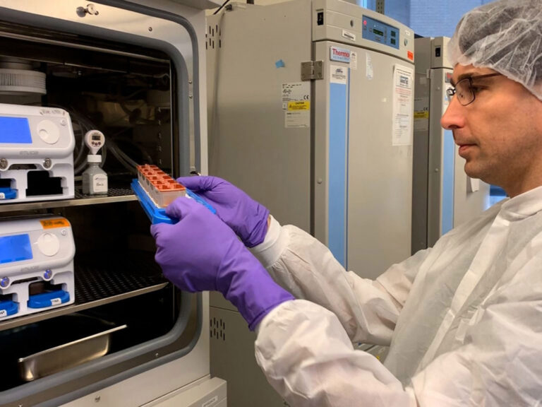 A researcher putting test tubes into a fridge