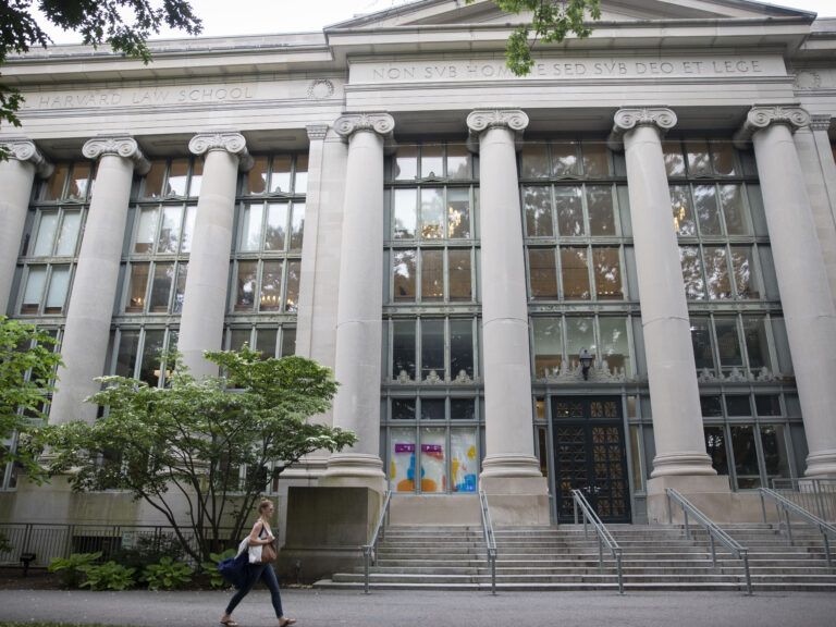 A woman walking by Langdell Library at the Harvard Law School