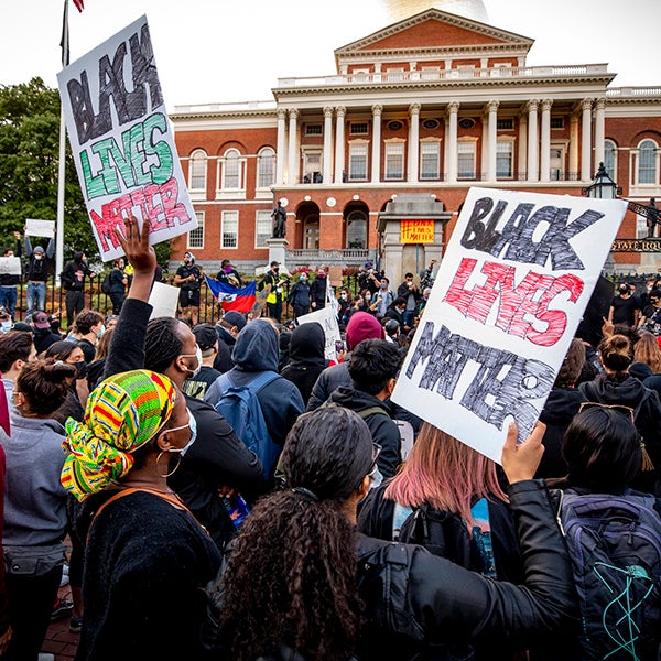 People hold Black Lives Matter signs at a protest 