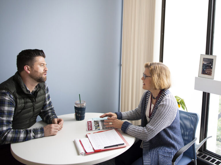 Two employees talking to each other in a meeting room.