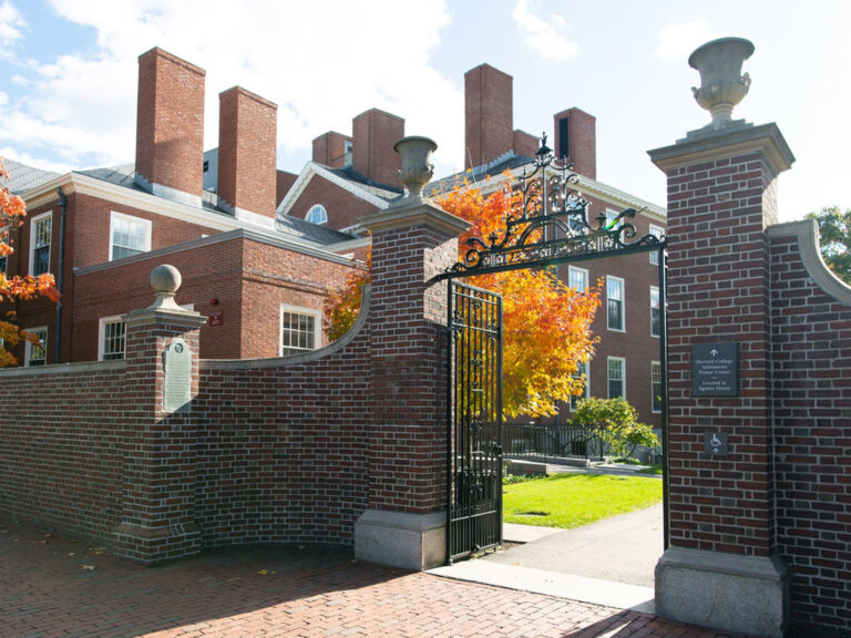 brick gates outside of the Radcliffe campus, with autumn foliage.