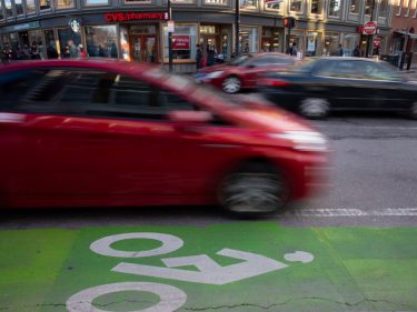 A car driving next to a bike lane
