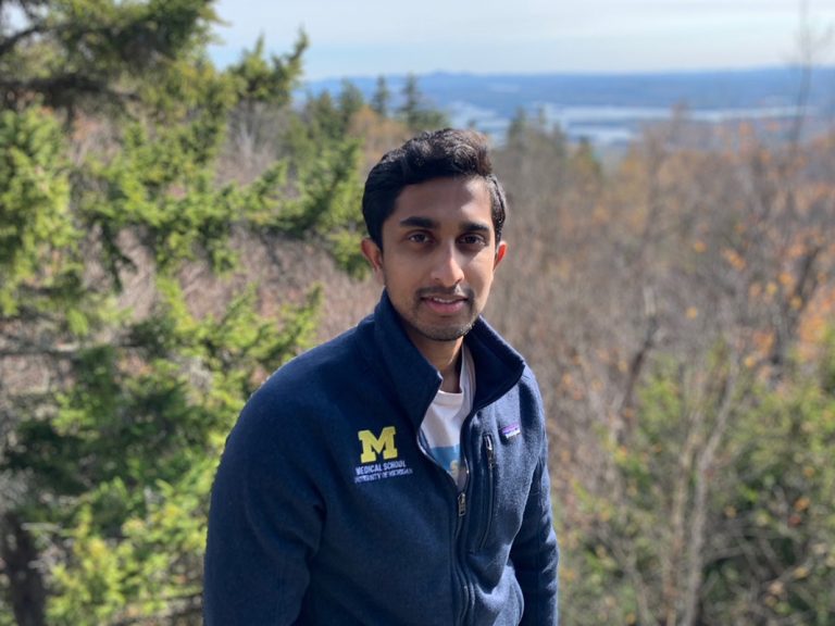 A student with views of trees and skies behind him