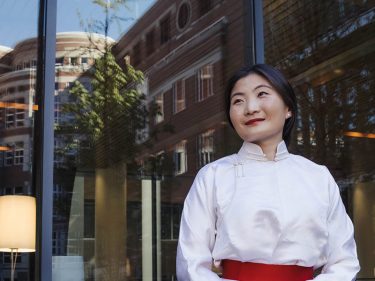 Ganchimeg Ganpurev in a white outfit standing outside a glass wall