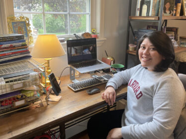 A student sits at a desk with a laptop