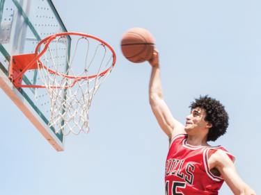 A man in a bulls jersey dunking a basketball