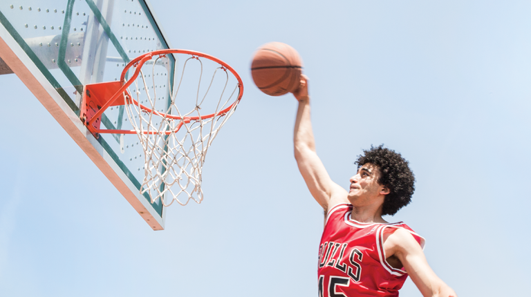 A man in a bulls jersey dunking a basketball