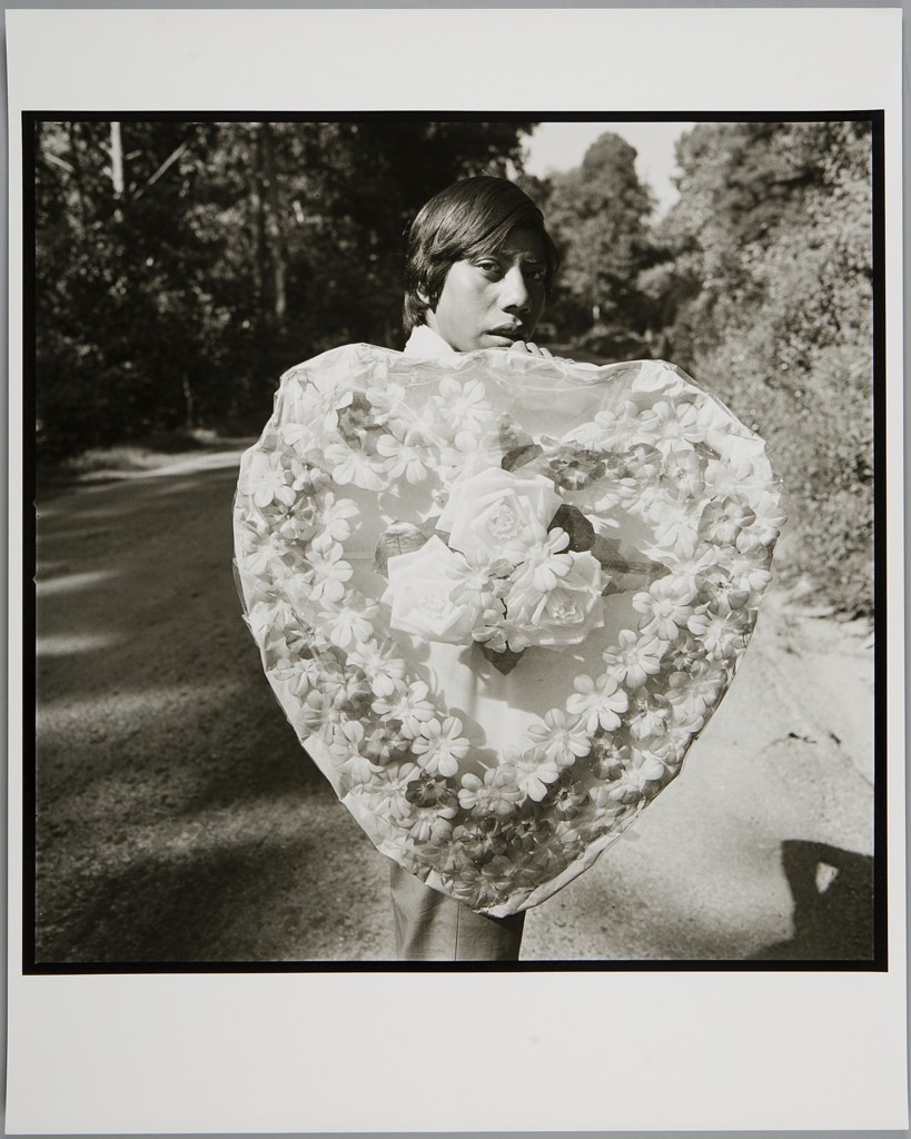 A black and white photo of a boy holding a large heart