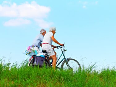 Two elderly people riding bikes