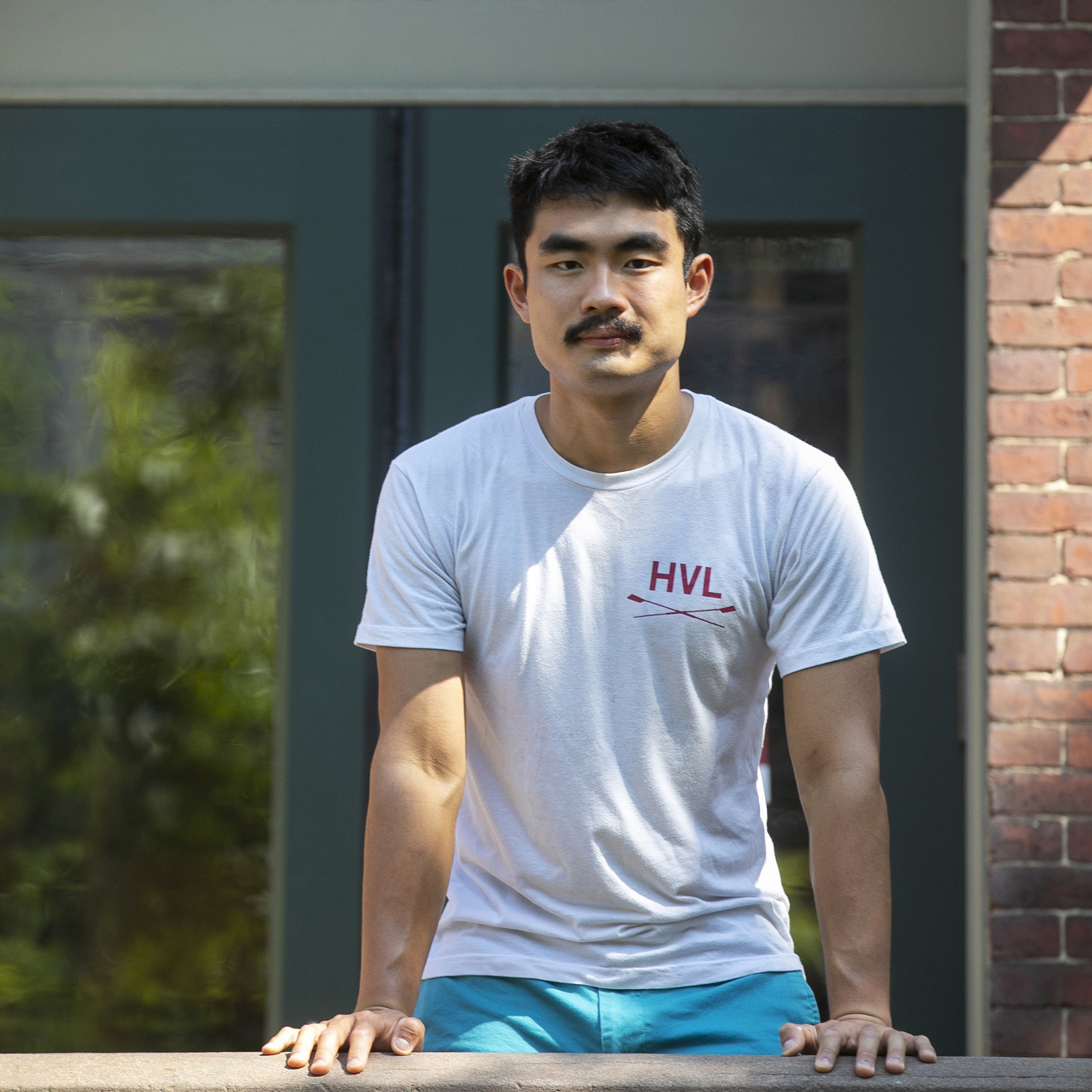 A student stands in front of a Harvard building