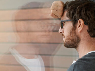A young man with his head pressed up against a window