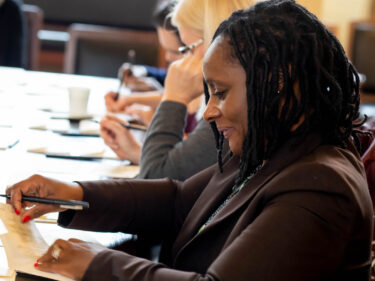 A Harvard staff member writes puts a thank-you card in an envelope