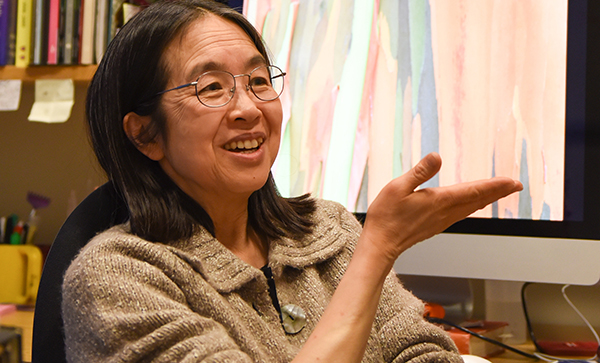 smiling woman speaking with her hand extended.