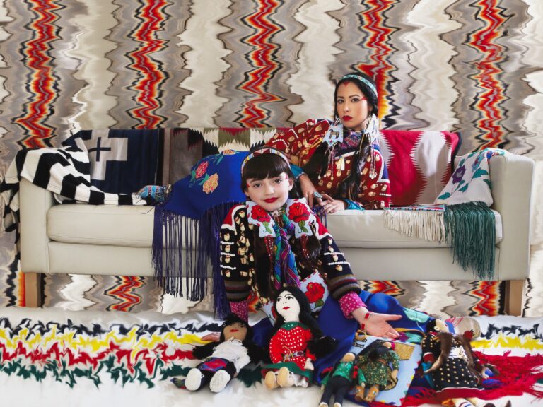 A woman lying on a couch and a child playing with toys