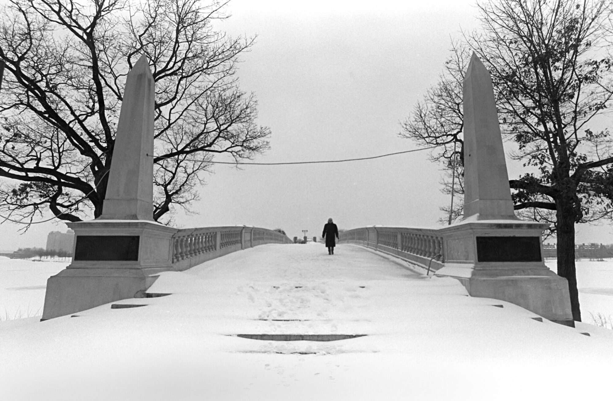 A person walking across a snowy footbridge