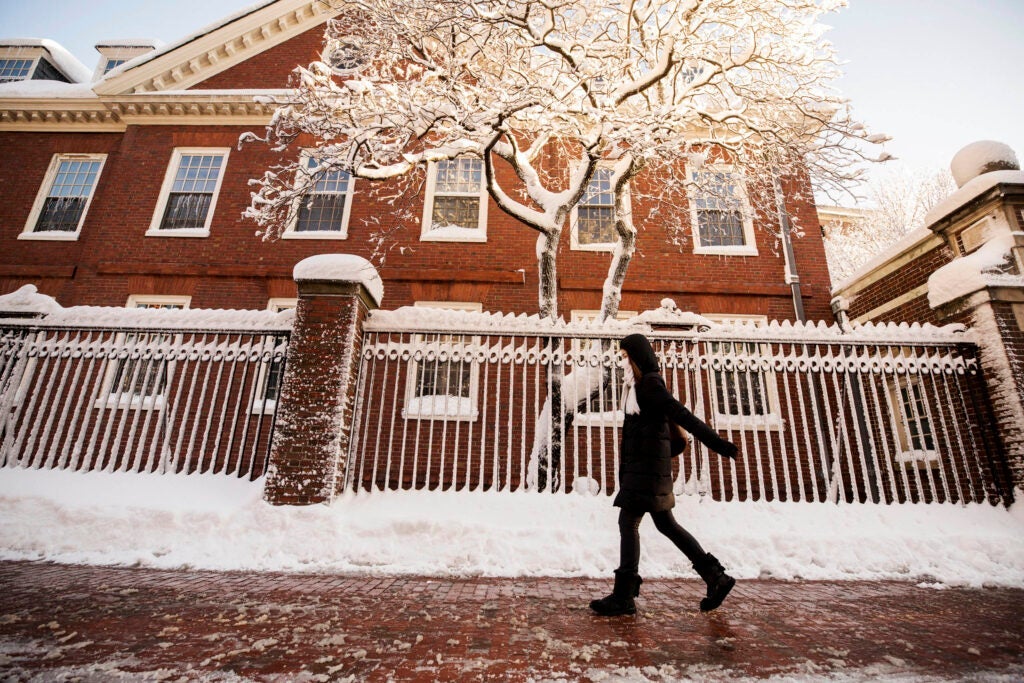 A student walking on a snowy sidewalk