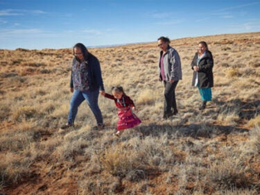 A family walks across a large open plain