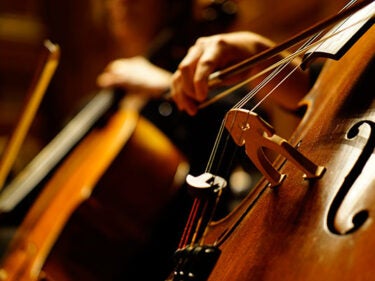 An up-close photo of a cello being played