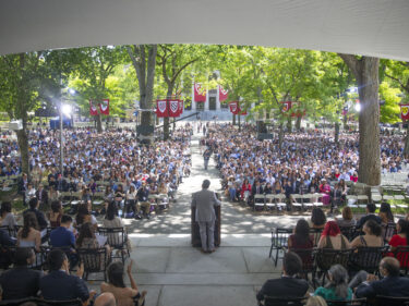 A speaker at a podium facing a huge audience