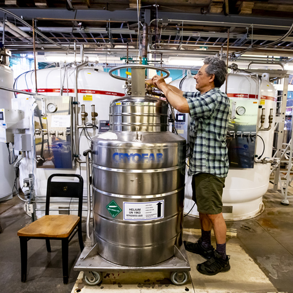 A man fills a helium tank