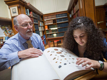 Two people looking at a book of truffles