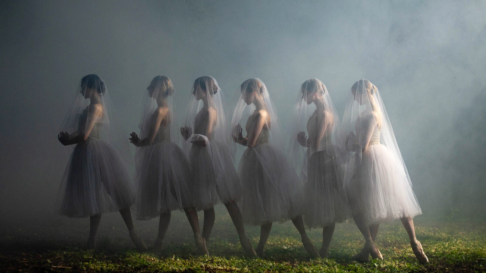 Ballet dancers posed in fog.