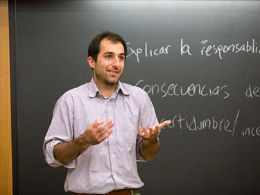 A man standing in front of a board full of Spanish words
