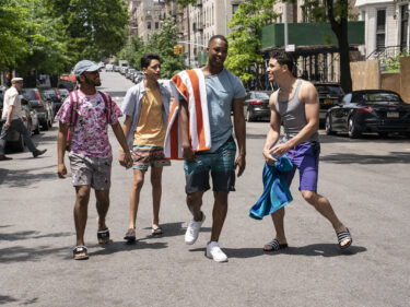 Four young men walking on a street