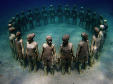 Statues of people standing underwater