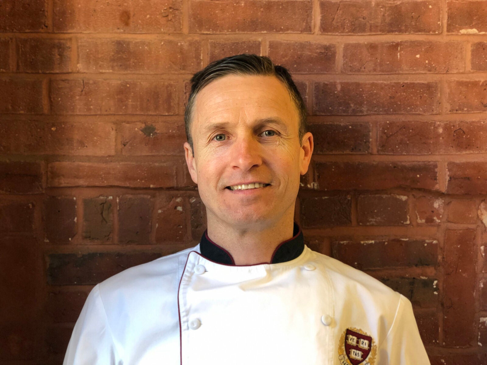 Headshot of chef Ludger Wessels against a brick wall