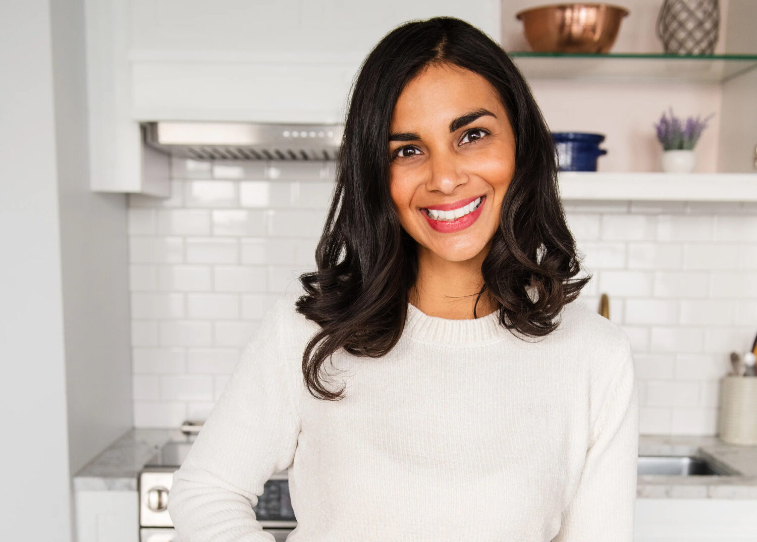 A woman stands in a kitchen