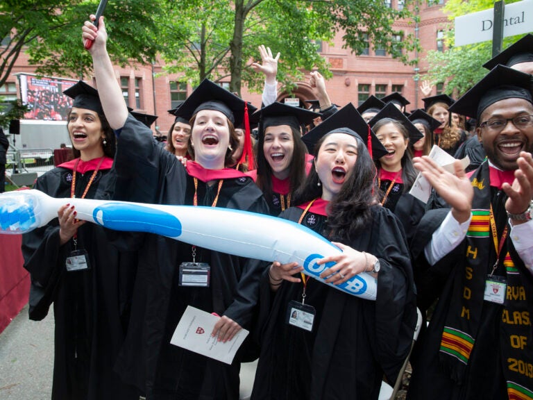 Graduates holding an inflatable toothbrush