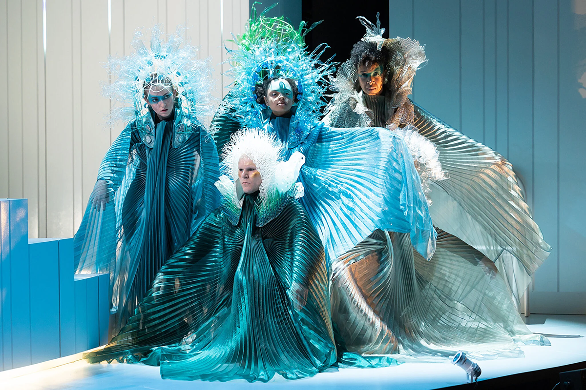 Performers wear elaborate blue, ocean-like costumes