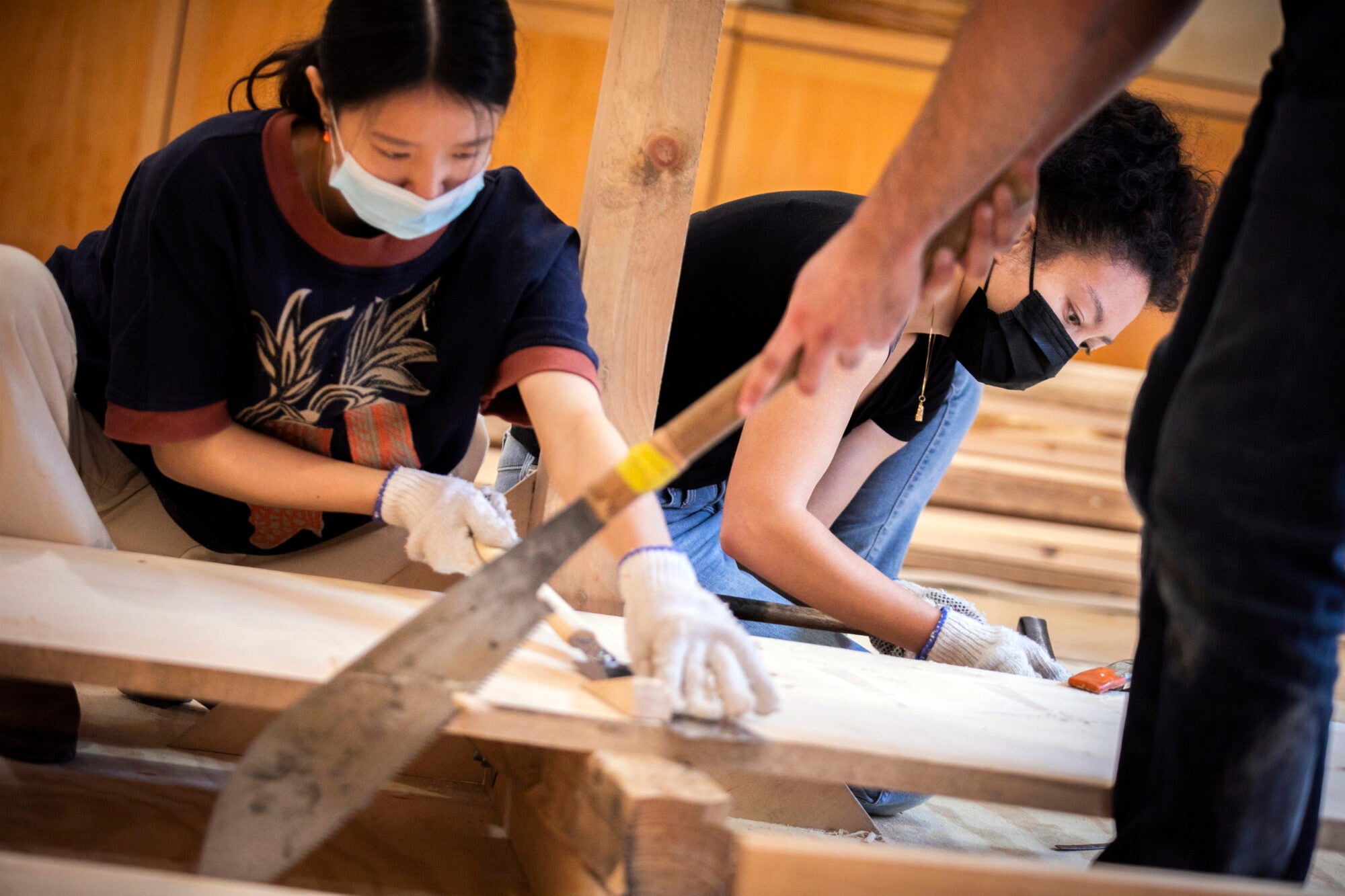 Students work on a wooden boat