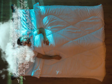 A person lays in a bed with text in different languages floating above their heads, as if they are dreaming