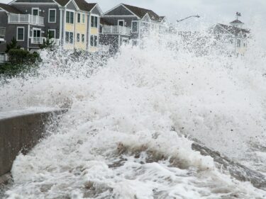 ocean waves splashing near houses