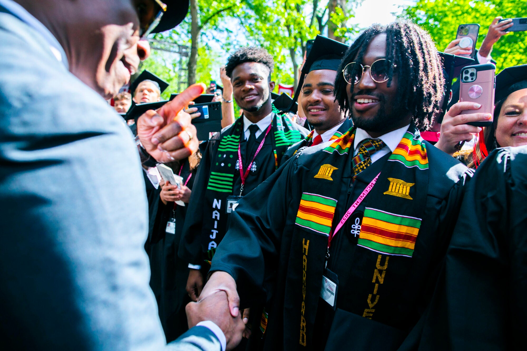 Graduates shaking hands with a man